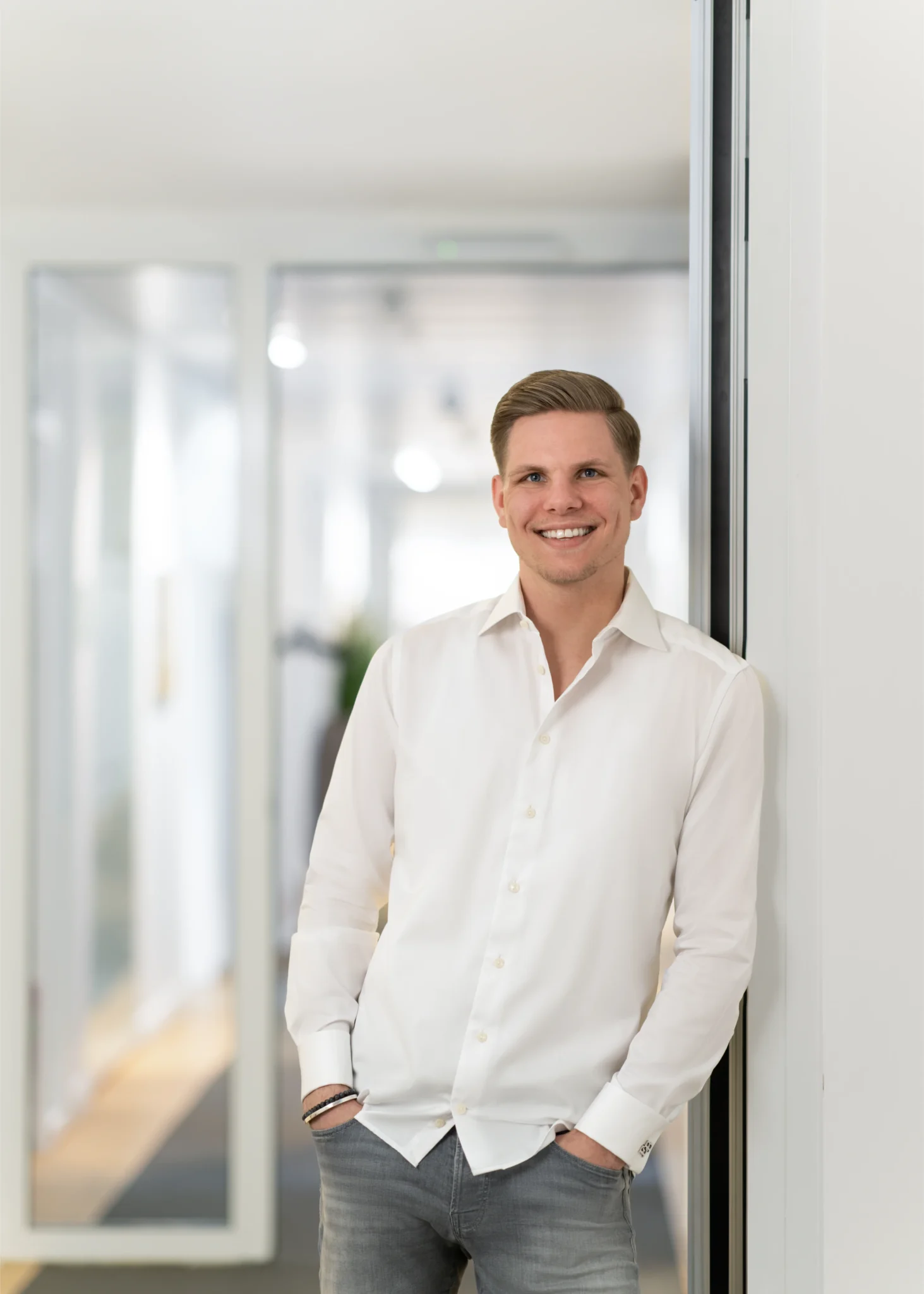 Erik Bernsjann In Heller Kleidung Im Büroflur, Lächelnd Mit Händen In Den Taschen